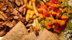 Sātīgais cāļa kebaba gaļas šķīvis ar kartupeļiem frī un tortilju