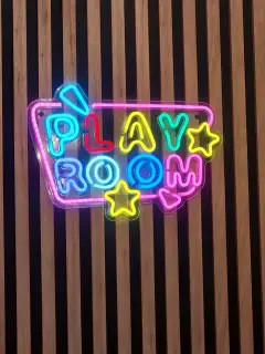 PLAY ROOM neona zīme pie rotaļu istabas